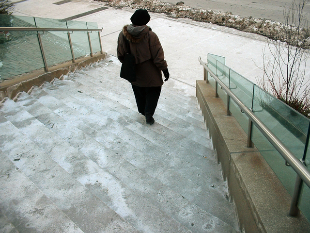 Vonkajšie schodisko, staršia žena ide po schodoch, sneh, zima.jpg